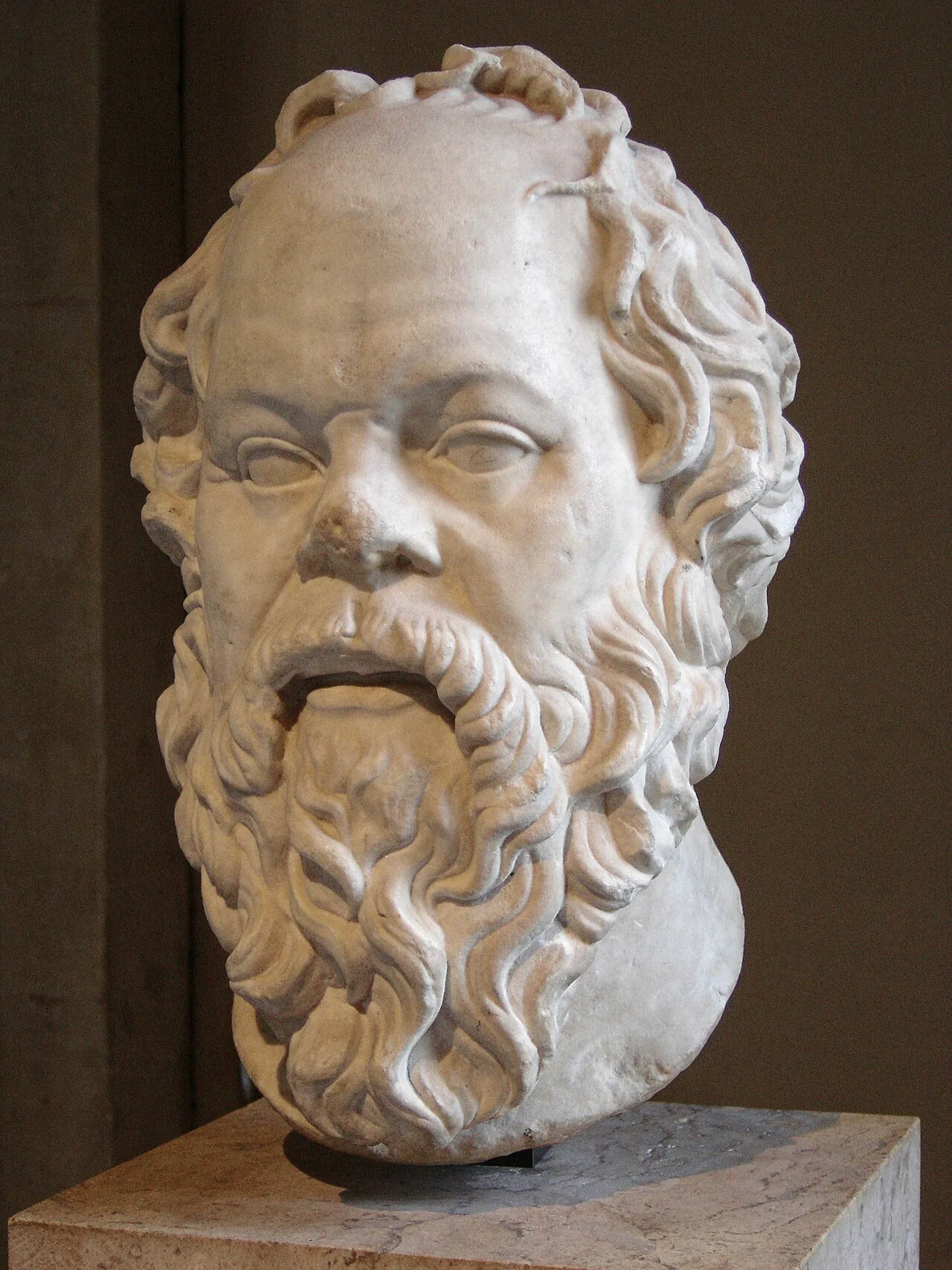 Marble bust of Socrates with a broad nose and full beard.